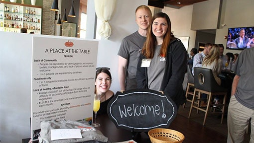 Volunteers welcoming guests at a table