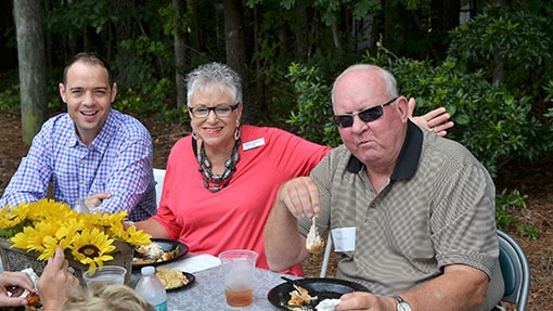 Three senior adults sharing a meal outside