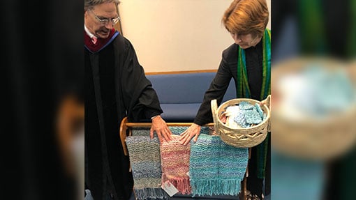 Two ministers displaying a prayer shawl