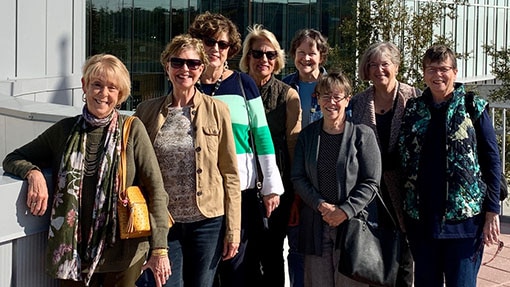 A group of women smiling together outside of a building