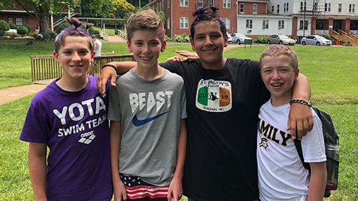 Four middle school boys pose for camera at a summer camp