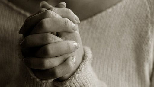 Female hands clasped together in prayer