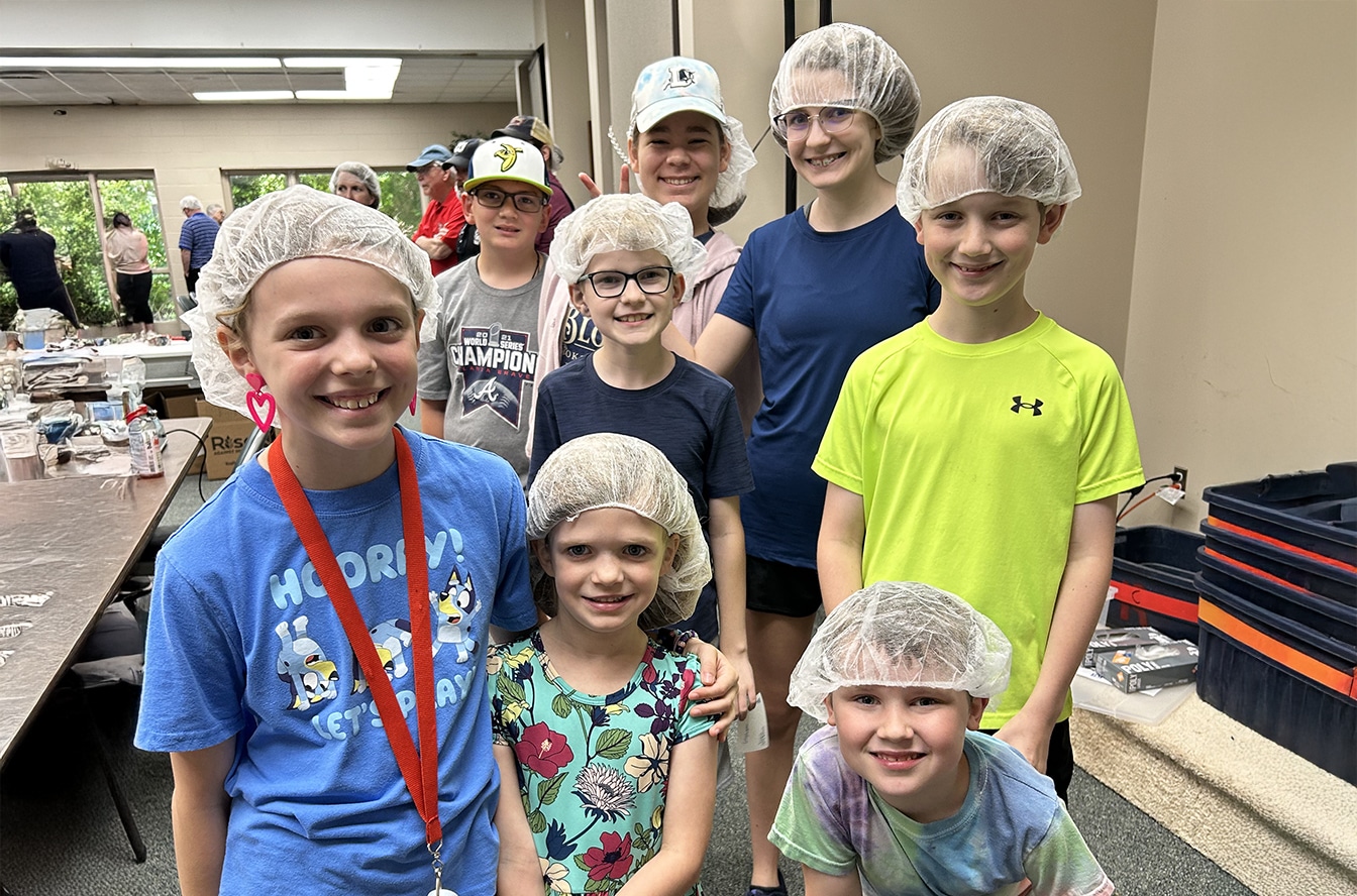 Mother and son wearing masks near their red car