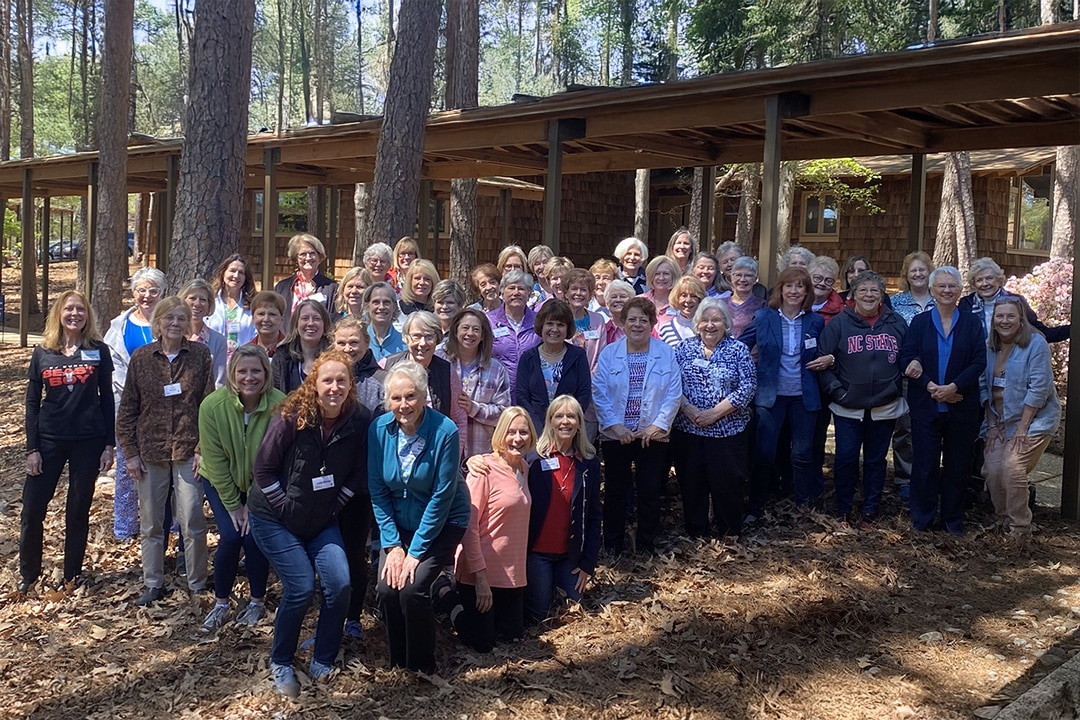 A group of women smiling together outside of a building